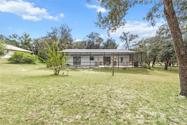 rear view of house with a lawn and a lanai