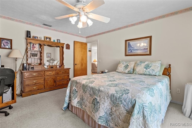 carpeted bedroom with ceiling fan and a textured ceiling