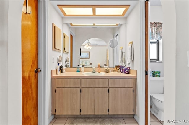 bathroom with tile patterned floors, ceiling fan, vanity, and toilet