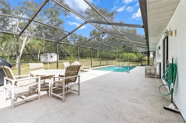 view of pool featuring a lanai, a patio area, area for grilling, and a storage unit