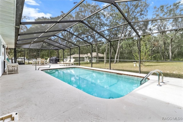 view of swimming pool featuring a patio area, a yard, and glass enclosure