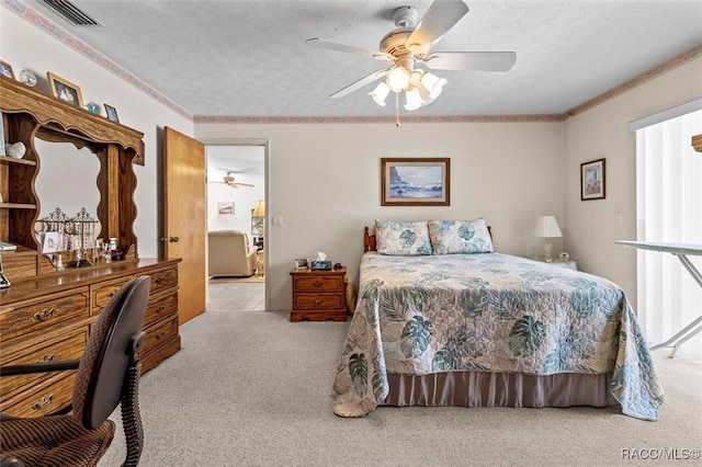 carpeted bedroom with a textured ceiling, ceiling fan, and ornamental molding