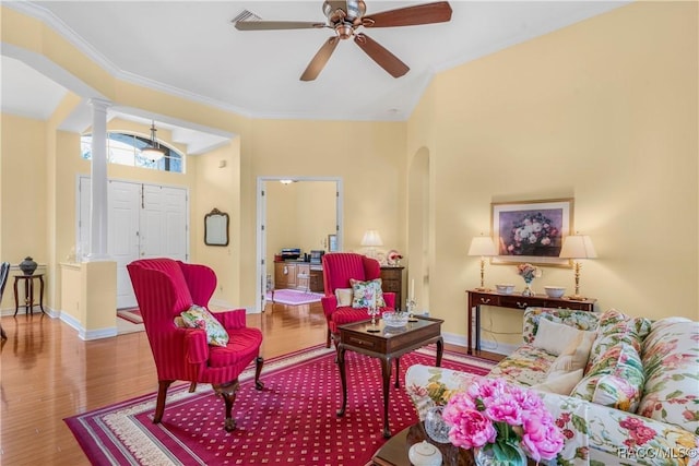 living room with hardwood / wood-style flooring, ceiling fan, ornamental molding, and decorative columns