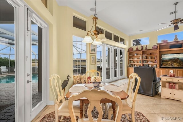 tiled dining room featuring ceiling fan with notable chandelier and french doors