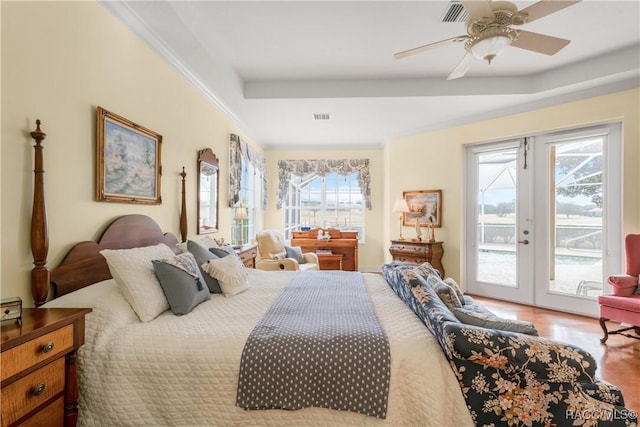 bedroom with light hardwood / wood-style flooring, ceiling fan, french doors, access to outside, and a raised ceiling