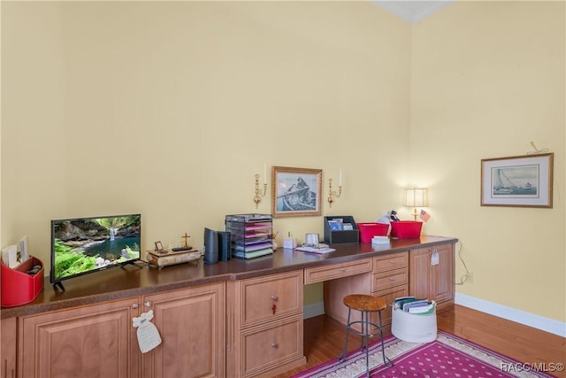 office featuring built in desk and hardwood / wood-style floors