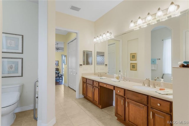 bathroom with tile patterned flooring, vanity, and toilet