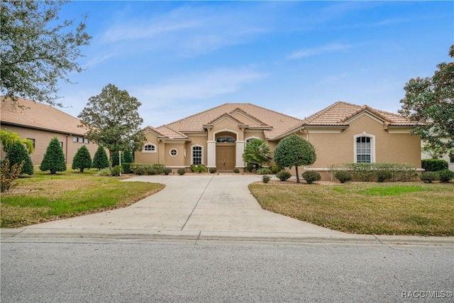 mediterranean / spanish home with a front yard