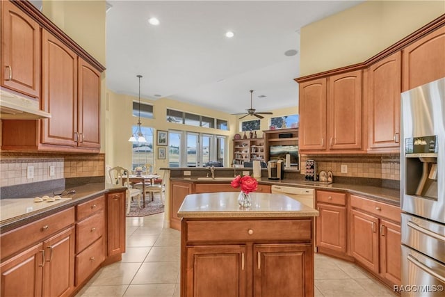 kitchen with white appliances, kitchen peninsula, hanging light fixtures, and a kitchen island