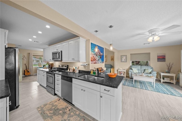 kitchen featuring pendant lighting, sink, ceiling fan, white cabinetry, and stainless steel appliances