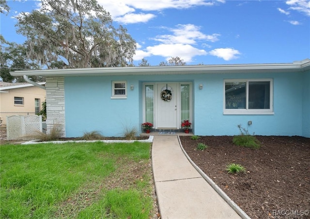 single story home featuring a front lawn