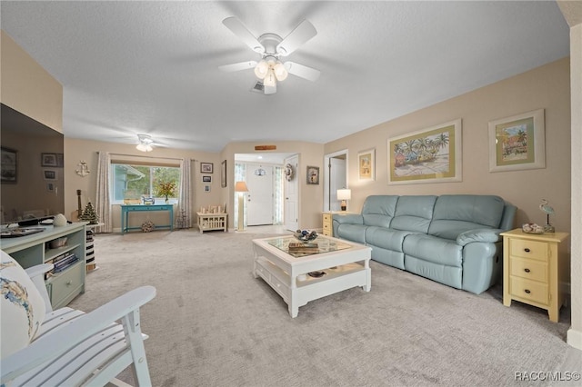 living room featuring a textured ceiling, ceiling fan, and light carpet