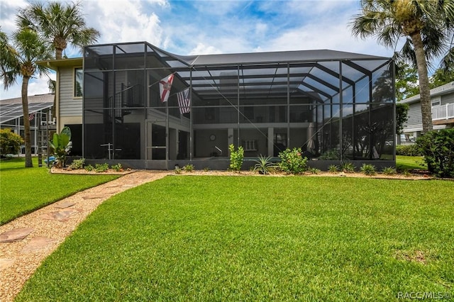 back of house with glass enclosure and a yard