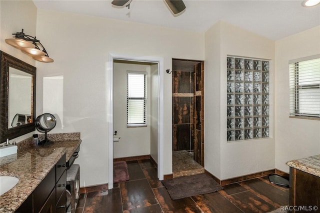 bathroom with ceiling fan, a shower, hardwood / wood-style floors, and vanity