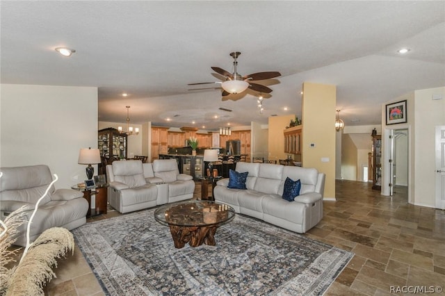 living room with lofted ceiling and ceiling fan with notable chandelier