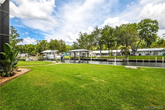 view of home's community featuring a boat dock, a yard, and a water view