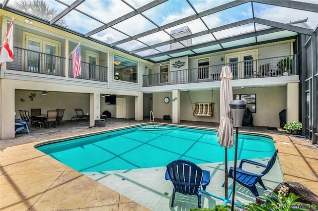 view of swimming pool featuring a patio area, a lanai, and ceiling fan