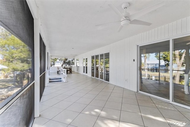 unfurnished sunroom featuring ceiling fan