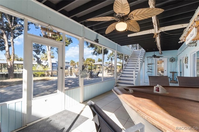 unfurnished sunroom with ceiling fan