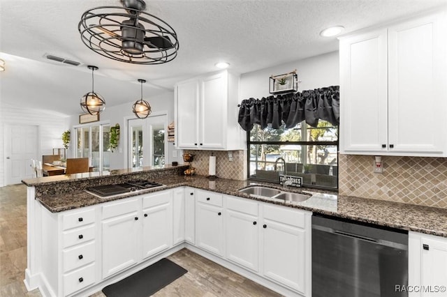 kitchen with appliances with stainless steel finishes, dark stone counters, sink, pendant lighting, and white cabinetry