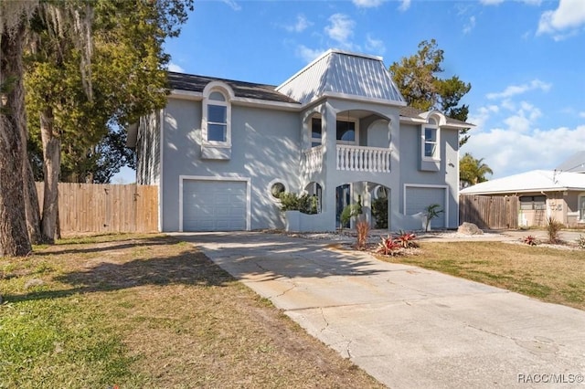 view of front of house with a front yard, a balcony, and a garage