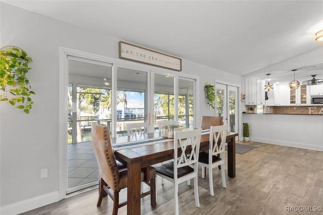 dining space with plenty of natural light, light hardwood / wood-style floors, and lofted ceiling