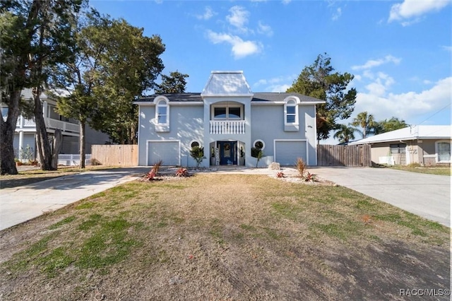 view of front of home featuring a balcony, a front yard, and a garage