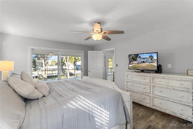 bedroom with ceiling fan, dark hardwood / wood-style floors, a textured ceiling, and access to outside