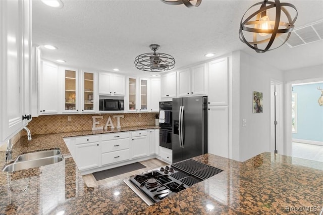 kitchen with tasteful backsplash, sink, black appliances, decorative light fixtures, and white cabinets