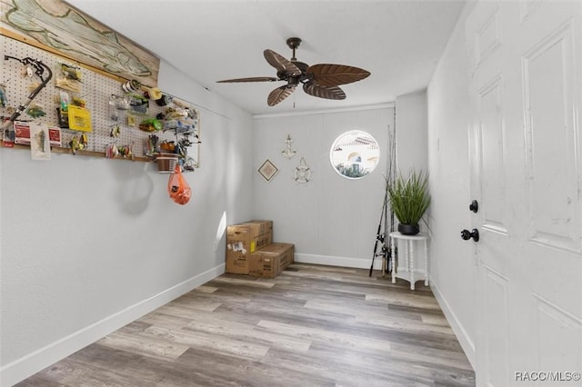 interior space with a workshop area, ceiling fan, and light hardwood / wood-style flooring