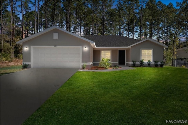 ranch-style home with a garage and a front lawn