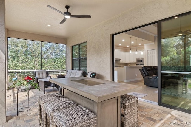 sunroom / solarium with sink and ceiling fan