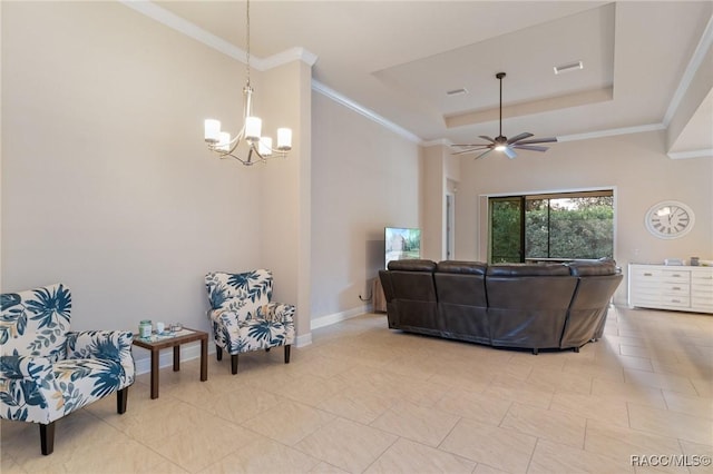 living room featuring ceiling fan with notable chandelier, ornamental molding, and a raised ceiling