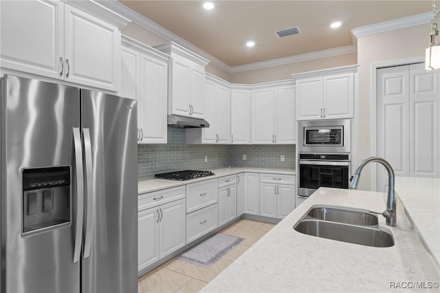 kitchen with pendant lighting, white cabinetry, sink, light stone counters, and stainless steel appliances