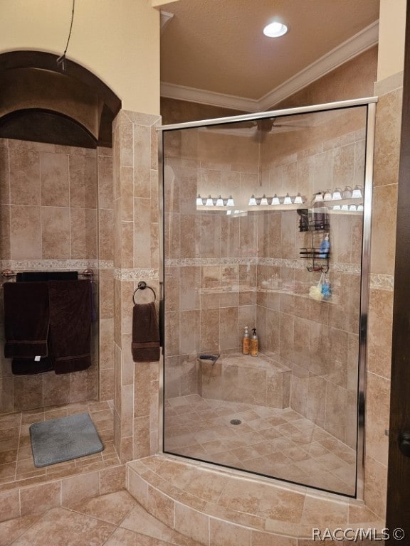 bathroom featuring tiled shower, vaulted ceiling, and ornamental molding