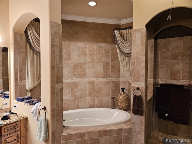 bathroom with tiled bath, vanity, tile walls, and ornamental molding