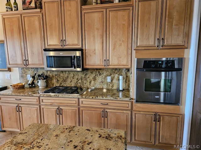 kitchen with decorative backsplash, light stone countertops, and stainless steel appliances