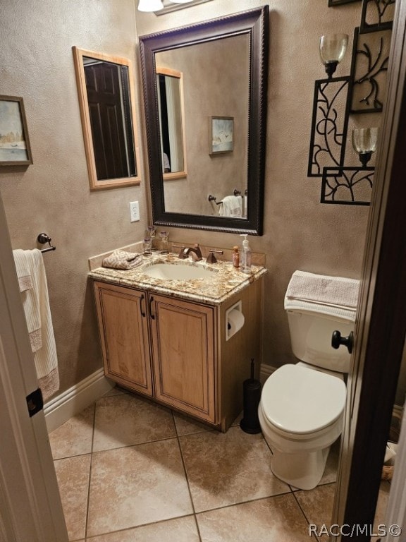 bathroom featuring tile patterned flooring, vanity, and toilet