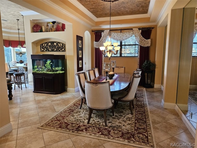 dining room featuring a tray ceiling, a chandelier, and ornamental molding