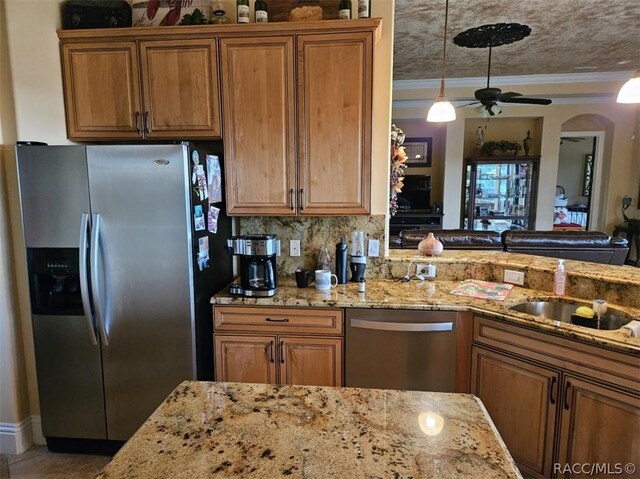 1103 W Pointe Vista Path Unit A4, Hernando, FL 34442 - kitchen featuring appliances with stainless steel finishes, brown cabinetry, light stone countertops, and crown molding
