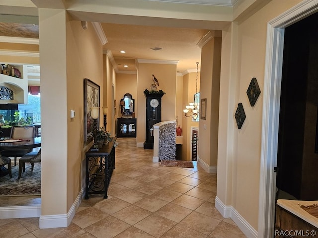 hall featuring ornamental molding, light tile patterned floors, and an inviting chandelier