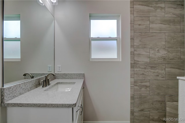 bathroom with vanity and a tile shower