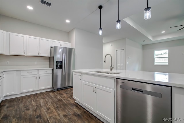 kitchen featuring stainless steel appliances, dark wood-type flooring, sink, white cabinetry, and hanging light fixtures