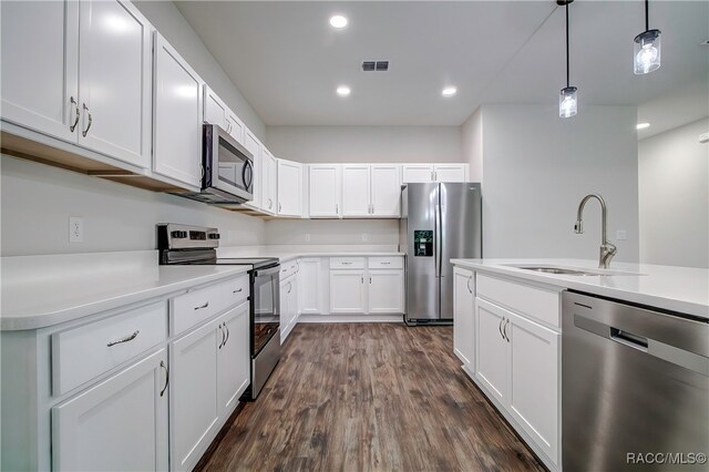 kitchen with pendant lighting, sink, dark hardwood / wood-style floors, appliances with stainless steel finishes, and white cabinetry