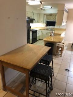 3621 N Lucille Dr, Beverly Hills, FL 34465 - kitchen featuring ceiling fan, light tile patterned floors, stove, and light countertops