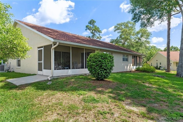 3621 N Lucille Dr, Beverly Hills, FL 34465 - back of property featuring a sunroom, a lawn, and stucco siding