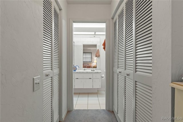 3621 N Lucille Dr, Beverly Hills, FL 34465 - corridor featuring light colored carpet, light tile patterned floors, a textured wall, and a sink