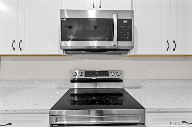 kitchen featuring white cabinetry, appliances with stainless steel finishes, and light stone counters