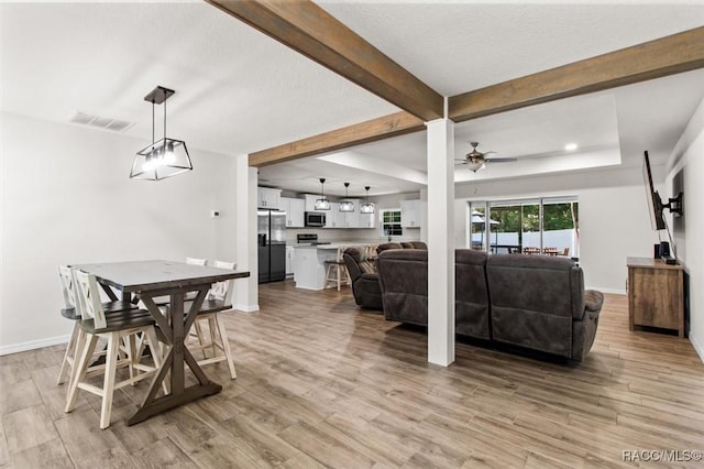 dining room with visible vents, ceiling fan, light wood-style flooring, and beam ceiling