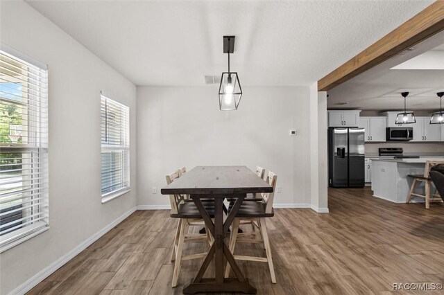 dining space with wood finished floors and baseboards